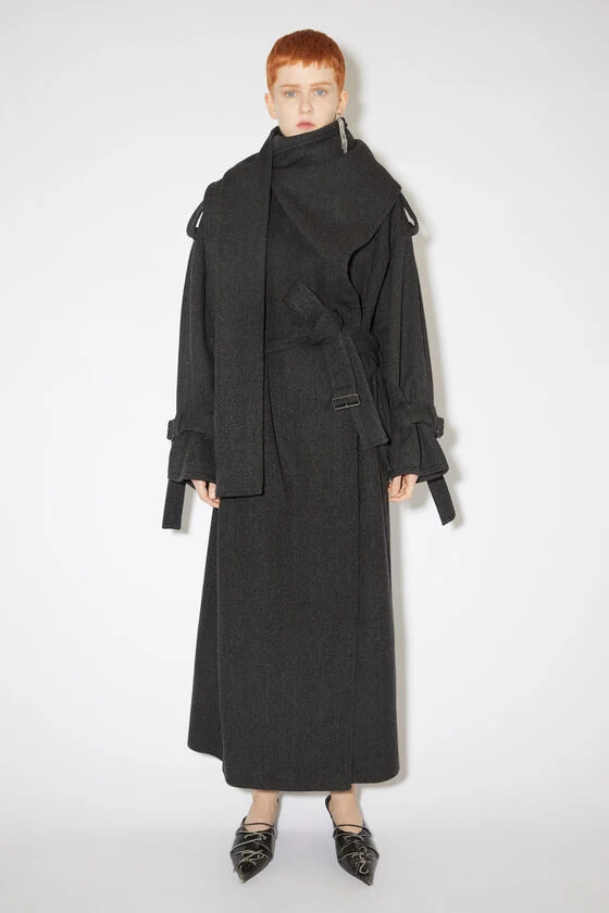 Photo du Scarf Collar Trench Coat d'Acne Studios : manteau long en laine mélangée noir, doté d'un col écharpe intégré, d'un double boutonnage et d'une ceinture à nouer, pour un style décontracté et élégant cet hiver.